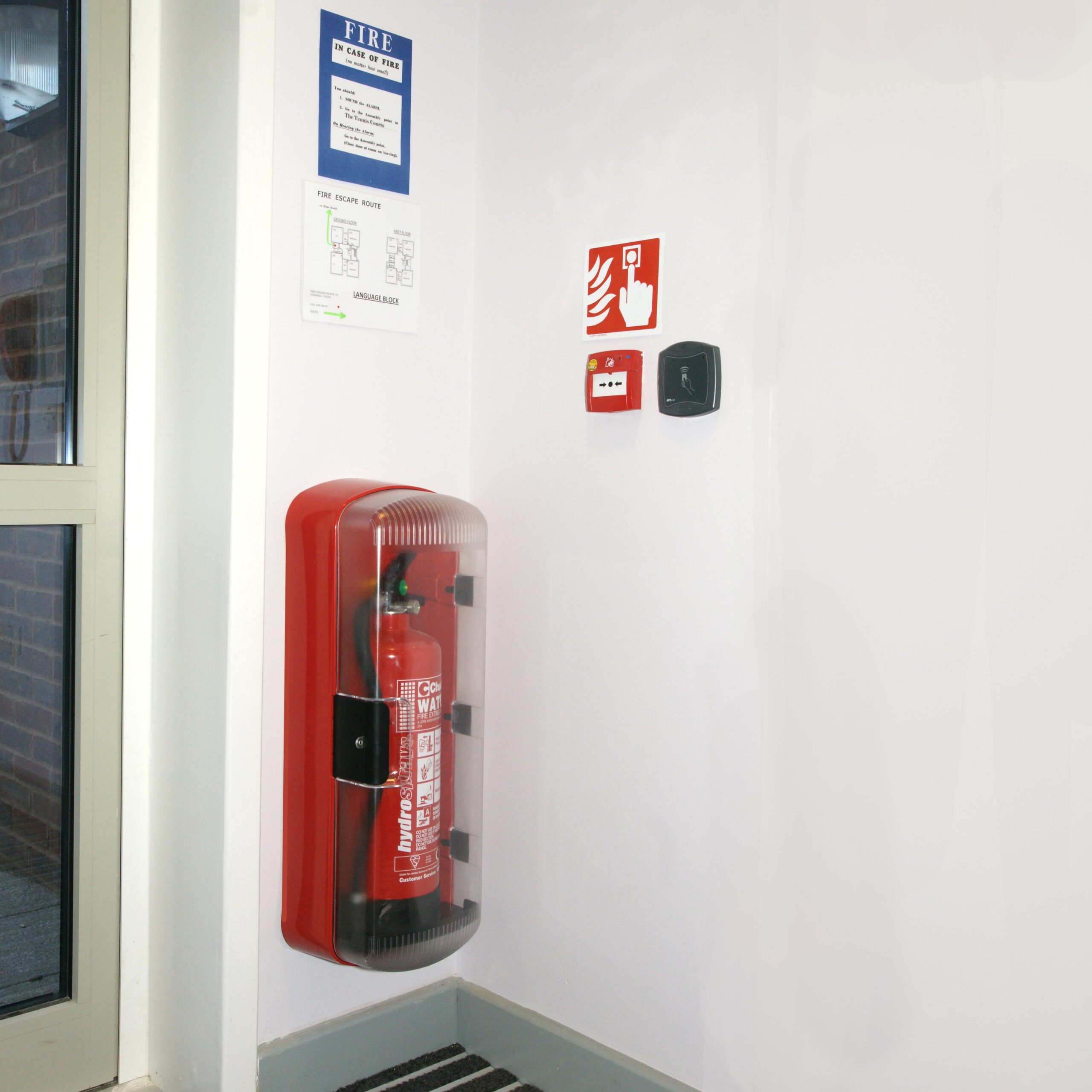 SOS101 fire extinguisher cabinet by a doorway in a school