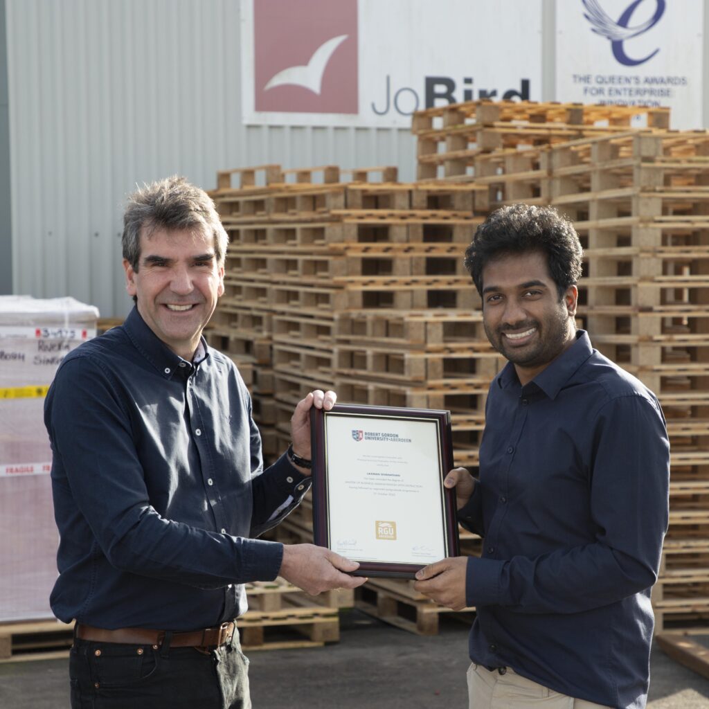 Guy Atkins, MD for Jo Bird and company holding the MBA certificate with Laxman Sivanathan at the Jo Bird factory in Somerset.
